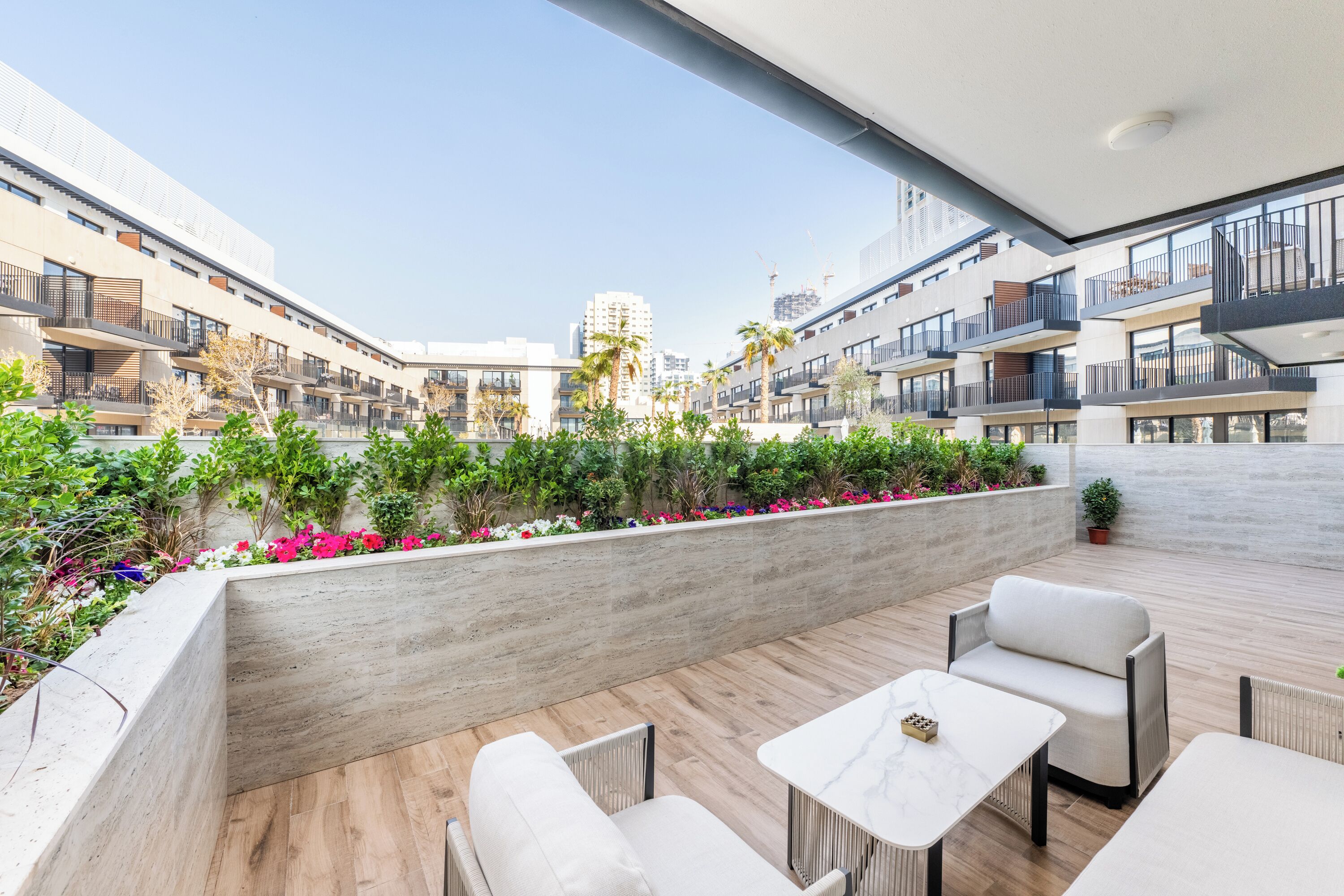 Un'area patio esterna moderna con posti a sedere e vista sugli edifici circostanti.