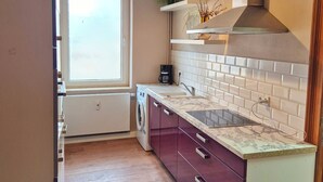 A compact kitchen with a built-in washing machine, a sink, and a stove.