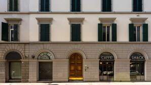 A building with a central entrance, arched doorways, and storefronts labeled 'CAFFE' FABBRI' and 'SNACK.' - Apartments Florence - Granduca Penthouse with stunning terrace (Florence)