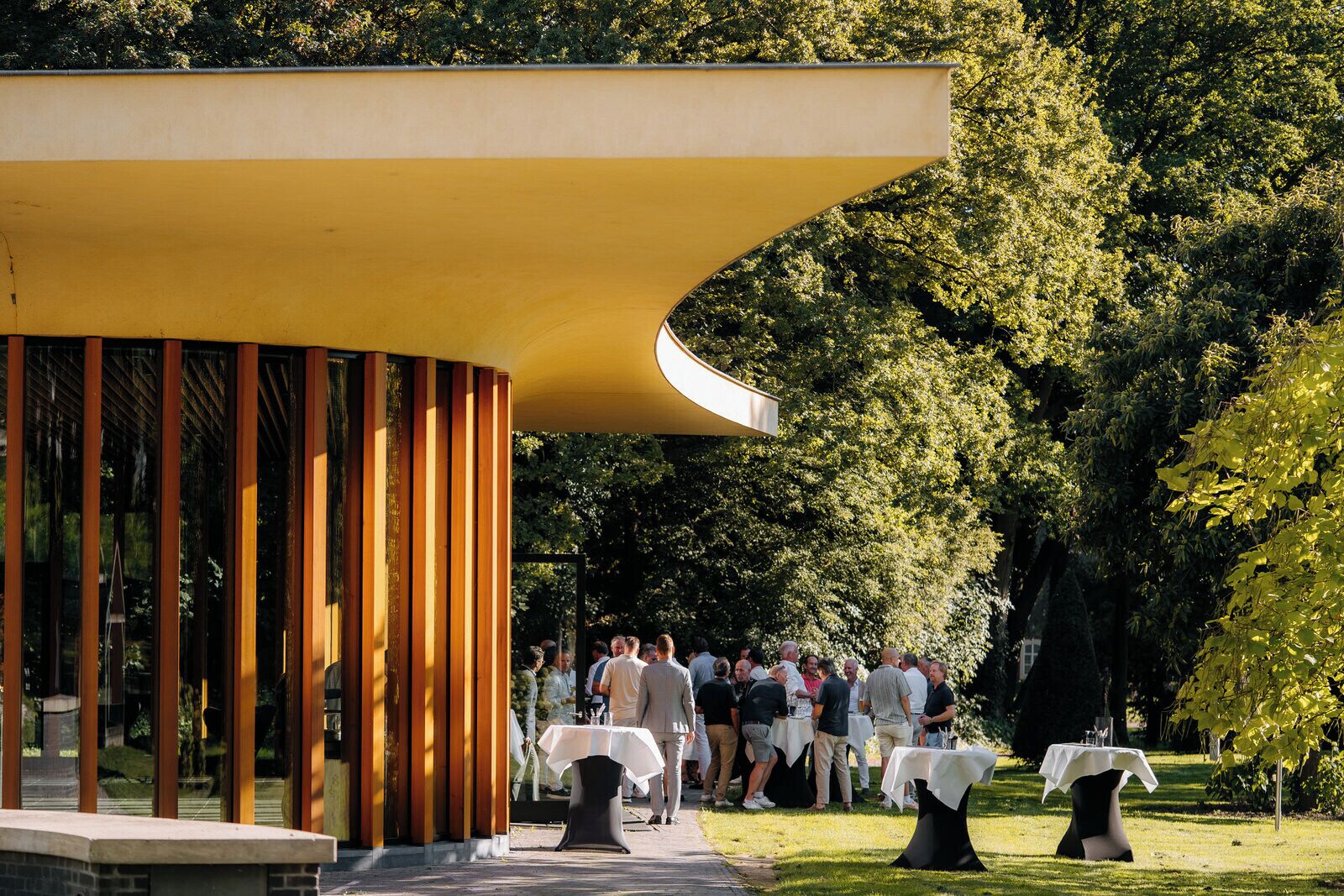 An outdoor event with a covered pavilion and tables set up for guests.