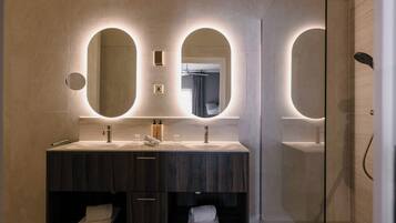 Une salle de bain moderne avec deux lavabos, un miroir et une douche.