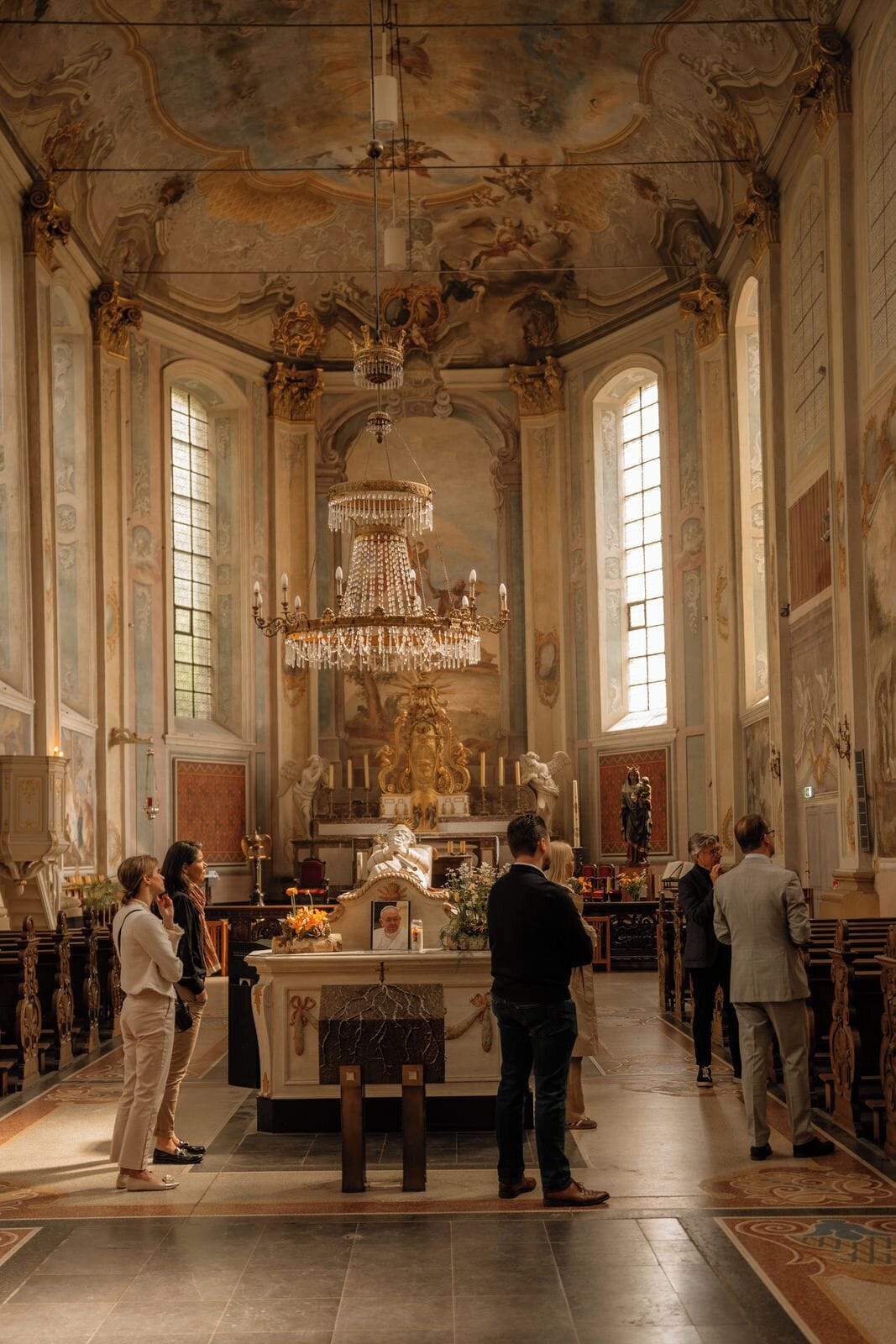 Interior de una iglesia ornamentada con un altar central, candelabros y estatuas religiosas.