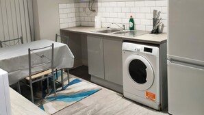 Eine moderne Küche mit Einbauwaschmaschine, Kühlschrank und Essbereich mit Tisch und Stühlen.