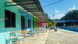 A resort with colorful buildings, outdoor seating, and a pool area.