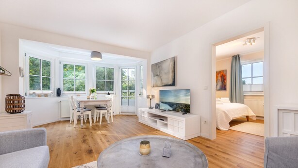 Amplia sala de estar con mesa de comedor, televisor y cómodo espacio de descanso.