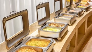 A buffet line with various food items in metal containers, including what appears to be scrambled eggs, macaroni and cheese, and other prepared dishes. - Vienna Hotel International Airport  (Guangzhou)