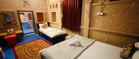 A hotel room with two beds, a red carpet, a mirror, and a wall with architectural details.