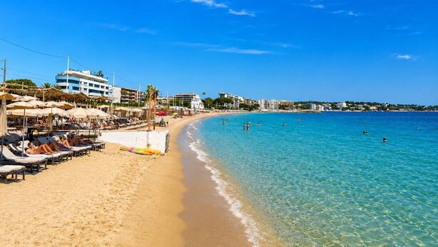A beach with sun loungers, umbrellas, and a clear blue sea. - Magnificent sea view (Juan les Pins)