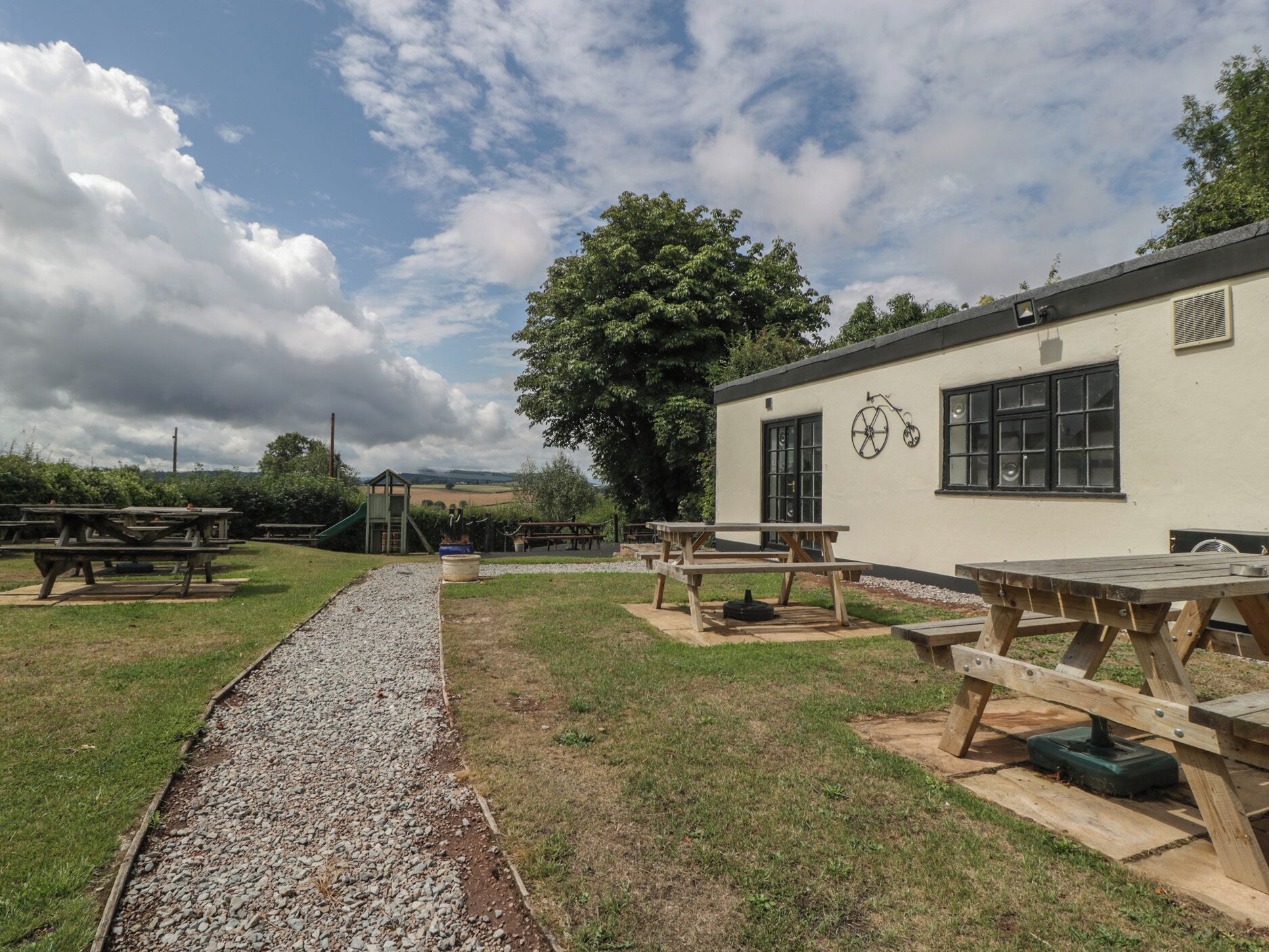An outdoor area with picnic tables and a playground.