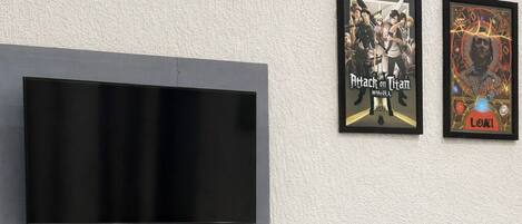 A modern room with a flat-screen TV mounted on the wall, a bench, and a green chair.