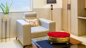 Un salon moderne avec un canapé, une lampe, un meuble en bois et un plateau décoratif orné de roses rouges.