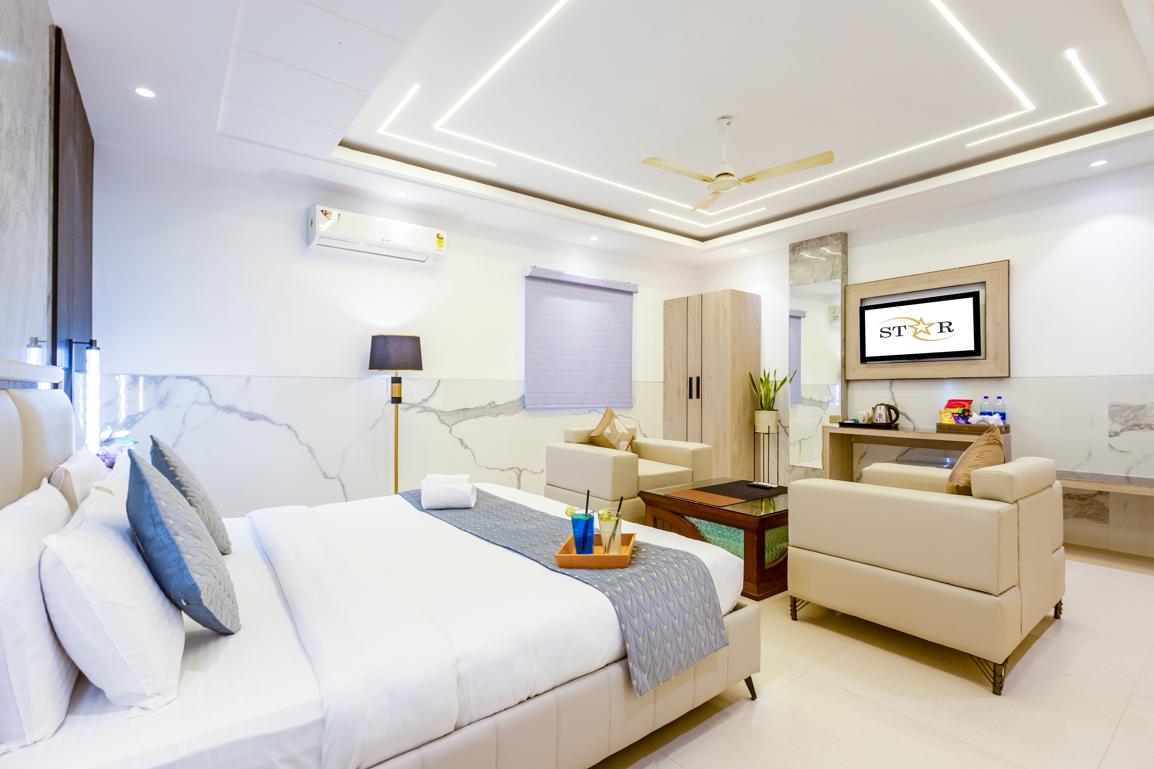 A modern hotel room with a bed, sofa, and desk.