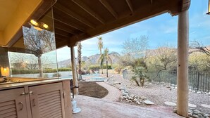 A covered patio area with a pool, a fountain, and a view of a desert landscape. - 1 Acre Estate Home,Mtn. Views,Pool,Billiards,Private Desert:Saguaro Sanctuary@Catalina Foothills (Tucson)