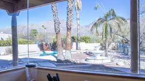 A kitchen with a blender, toaster, and knife block. A window reveals a backyard with a pool, palm trees, and mountains. - 1 Acre Estate Home,Mtn. Views,Pool,Billiards,Private Desert:Saguaro Sanctuary@Catalina Foothills (Tucson)