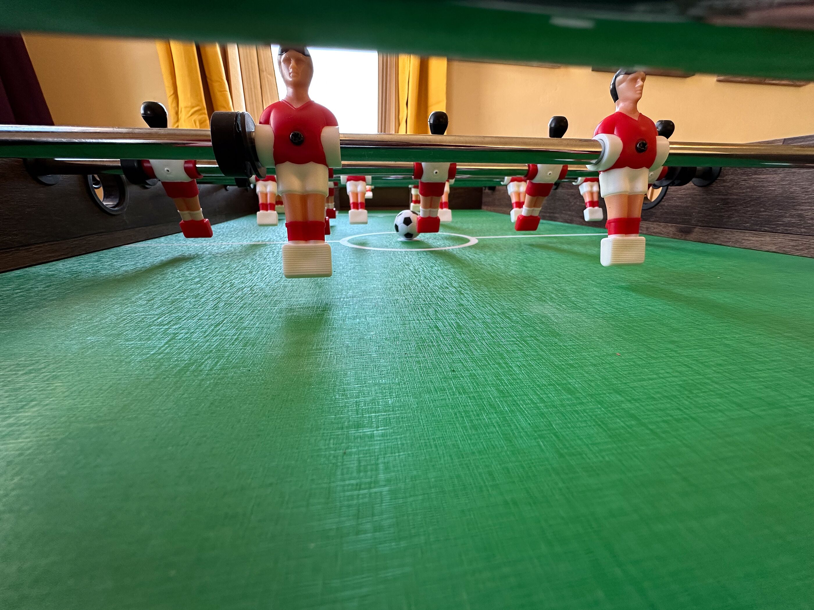 Ein Kicker mit zwei Spielern in roten und weißen Uniformen.