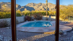 A pool with a mountain backdrop, surrounded by rocks and desert vegetation. - 1 Acre Estate Home,Mtn. Views,Pool,Billiards,Private Desert:Saguaro Sanctuary@Catalina Foothills (Tucson)