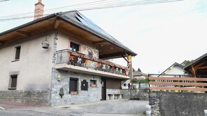 Un bâtiment à deux étages doté d’un balcon, d’une façade en pierre et d’un toit en bois.