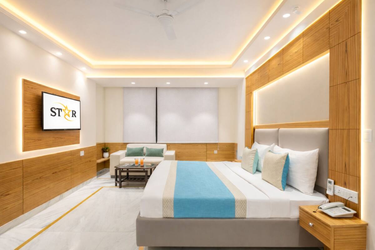 A modern hotel room with a large bed, bedside table, and a TV mounted on the wall.