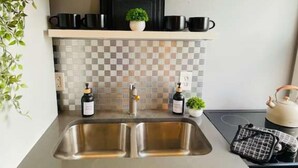 A kitchen with two sinks, a stove, and cabinets. - TopUnit Floor Near Airport One bedroom (Cleveland)