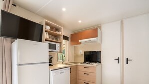 A compact kitchen with a refrigerator, microwave, stove, and a dishwasher. - Mobile Home 6 Pers - Terrace - Granges-Aumontzey (Granges-Aumontzey-Aumontzey)