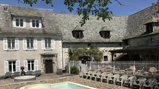 A courtyard with a swimming pool, stone buildings, and outdoor seating. - Spacious mobile home with terrace - 6 people (Argences-en-Aubrac)