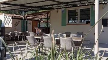 An outdoor patio with wicker furniture and a covered area.