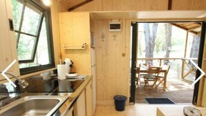 Une cuisine de taille réduite, équipée d’un évier, d’une cuisinière et d’une fenêtre.