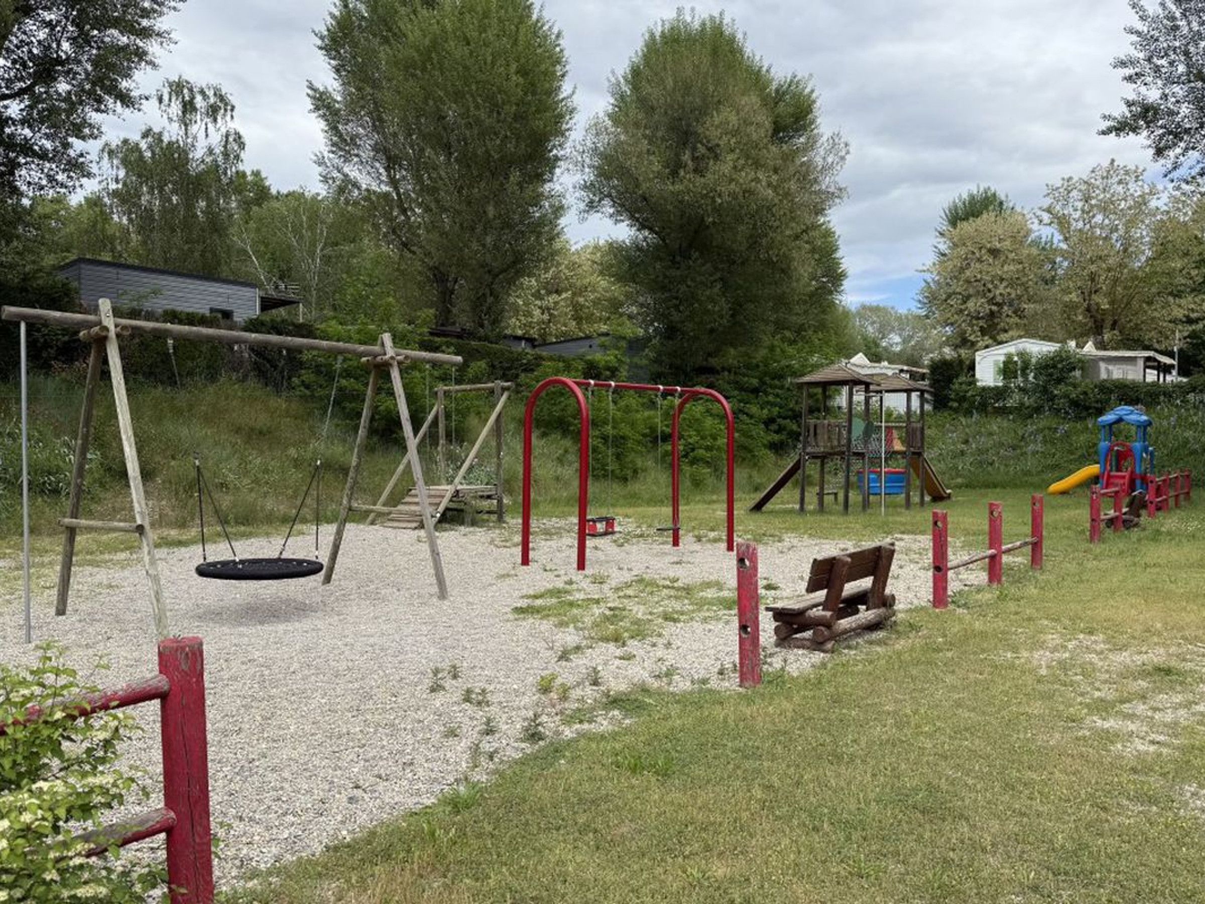 A playground with swings, a slide, and a climbing structure.