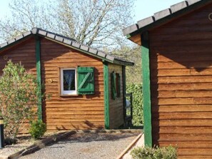 A wooden cabin with a small window and green shutters. - Cozy chalet with terrace in Naucelle - Idyllic location (Naucelle)