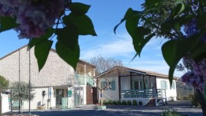Un bâtiment doté d’une façade en pierre, d’un porche abrité et d’une allée gravillonnée.