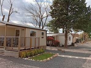 Una fila de casas móviles con un patio amurallado y un pequeño jardín.