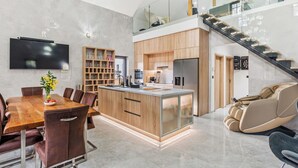 Una cucina moderna con mobili in legno, un'isola centrale e un'area pranzo con tavolo e sedie.