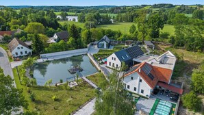Un quartiere residenziale con case, uno stagno e un edificio dotato di pannelli solari.