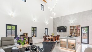 Un soggiorno moderno con camino, zona pranzo e cucina con televisore.