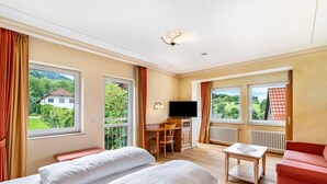 A hotel room with two beds, a desk, a TV, and a view of greenery. - Country House Room 'Lebensfreude' with Mountain View and Wi-Fi (Bühlertal)