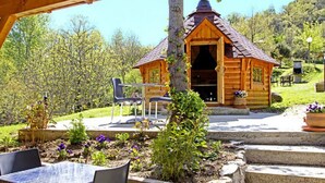 Eine Holzhütte mit Veranda, Tisch und Stühlen.