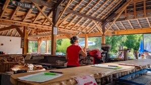 Une structure rustique en bois, sur laquelle est apposée une enseigne indiquant « TIKI BAR ».