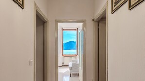 A hallway leading to a room with a view of the sea and mountains. - Nice apartment for 4 guests with WIFI, balcony and pets allowed (Argegno)