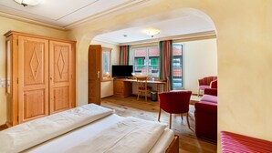 A hotel room with a bed, desk, TV, and seating area. - Country House Room 'Vogelsang' with Mountain View, Terrace and Wi-Fi (Bühlertal)