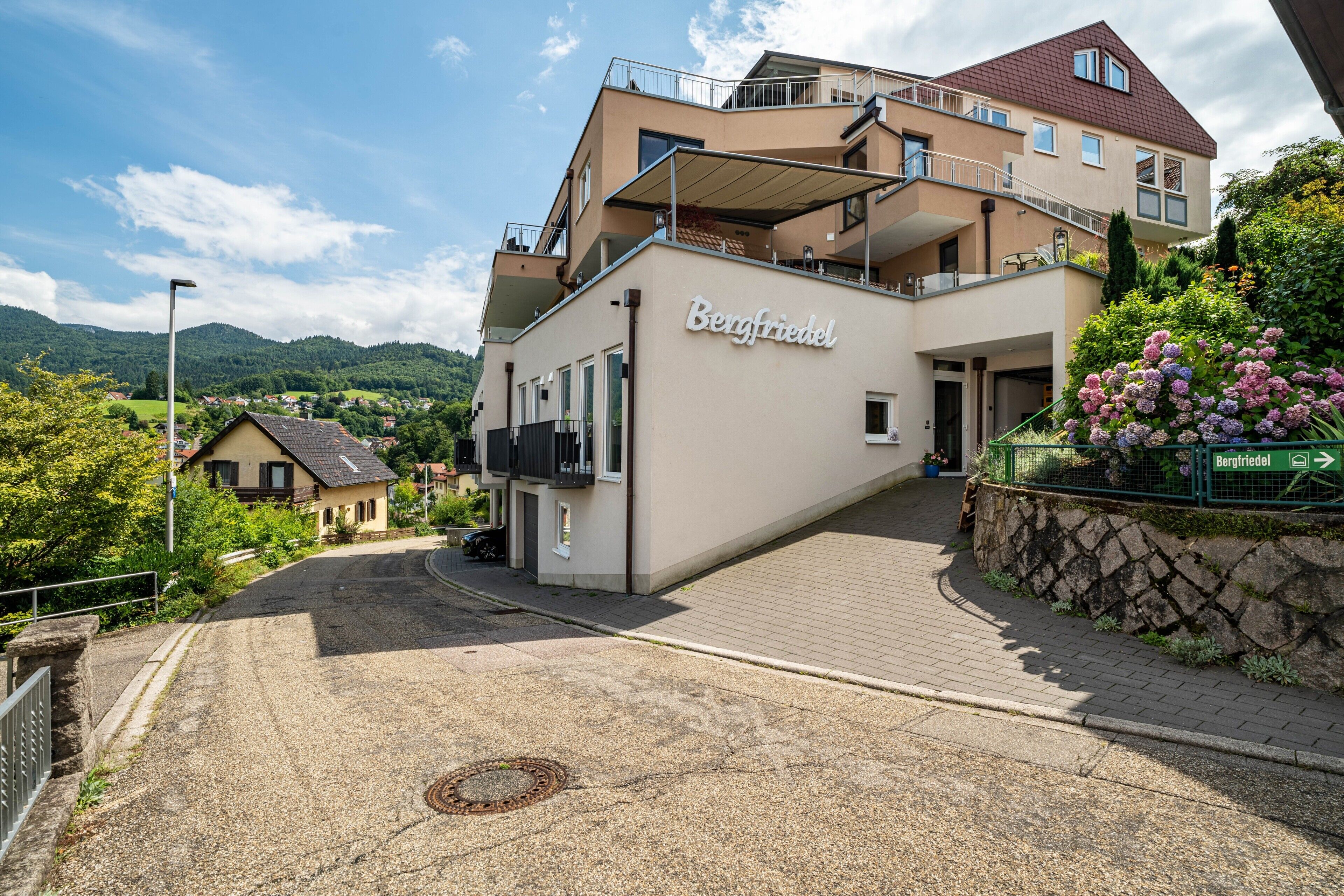 A multi-story hotel with a prominent name sign, a balcony, and a view of the surrounding landscape.