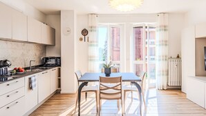 Eine moderne Küche mit Essbereich, Holzböden und Blick durch große Fenster.