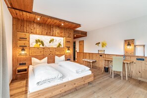 Une chambre à coucher en bois, avec un lit, des tables de chevet, un bureau et une chaise.