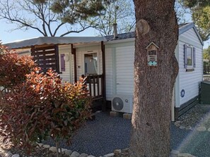 A mobile home with a porch, a small garden, and a tree with a birdhouse. - Mobile home with terrace for 6 people in Anduze (Anduze)