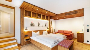 Une chambre à coucher avec un cadre en bois, comprenant un lit, un banc et une étagère fixée au mur.