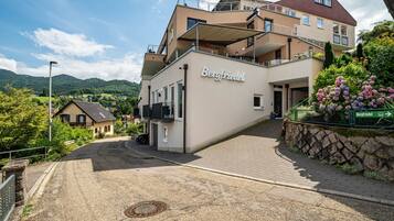 Ein mehrstöckiges Hotel mit auffälligem Namen, einem Balkon und Blick auf die umliegende Landschaft.