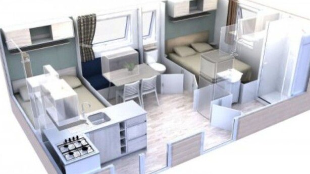 Un intérieur de camping-car compact et moderne, comprenant un coin cuisine, un espace repas, un coin nuit et une petite salle de bain.