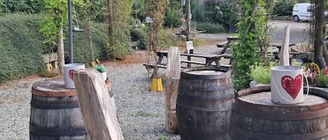 Outdoor seating with wooden barrels and a rustic setting.