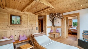 Een houten blokhut met een bed, een bank en een kleine tafel.