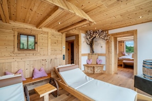 Eine Holzhütte mit einem Bett, einer Bank und einem kleinen Tisch.