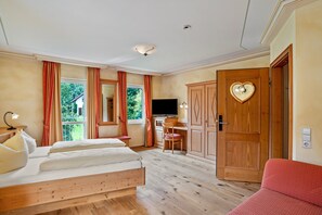 Ein Schlafzimmer mit einem hölzernen Bett, einem Schreibtisch, einem Fernseher und einem Kleiderschrank.